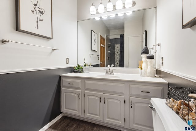 full bathroom featuring baseboards, walk in shower, wood finished floors, and vanity