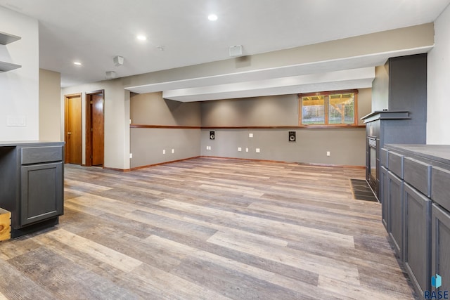basement with recessed lighting, baseboards, and light wood-type flooring