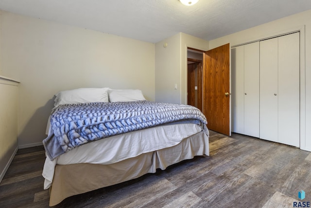 bedroom with a closet, baseboards, and wood finished floors