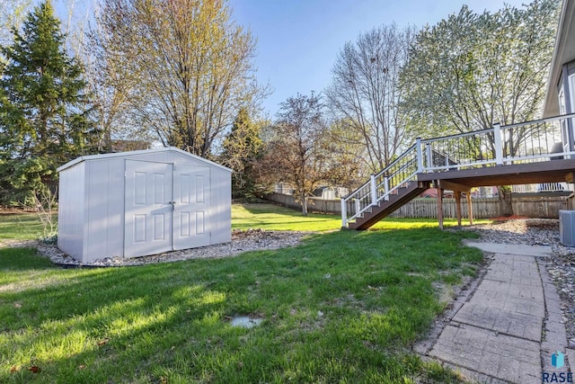 view of yard featuring an outdoor structure, fence, a shed, and stairs