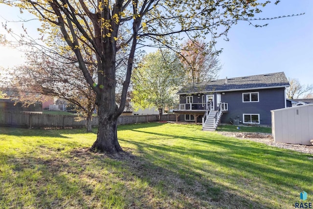 view of yard with stairs, a fenced backyard, and a wooden deck