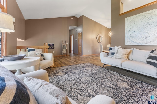 living room featuring baseboards, wood finished floors, and lofted ceiling
