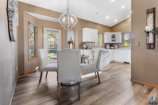 dining space featuring baseboards, light wood-style flooring, a notable chandelier, and a wealth of natural light