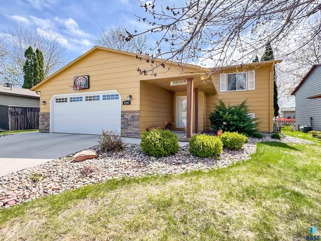 ranch-style house with an attached garage, fence, a front yard, and concrete driveway
