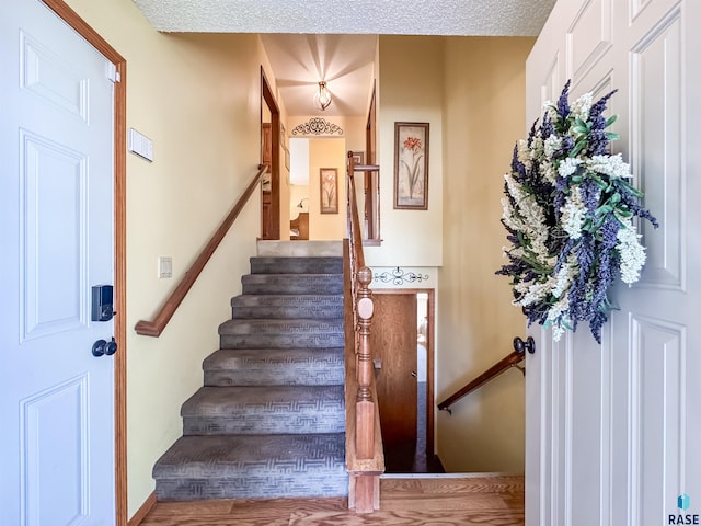 staircase featuring baseboards and wood finished floors