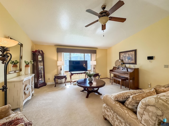 living area featuring baseboards, carpet flooring, ceiling fan, and lofted ceiling