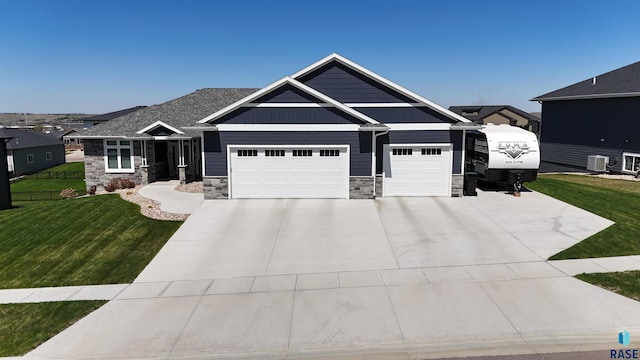 craftsman house with concrete driveway, a front yard, stone siding, and a garage