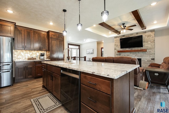 kitchen with a sink, dishwasher, dark wood finished floors, freestanding refrigerator, and a ceiling fan