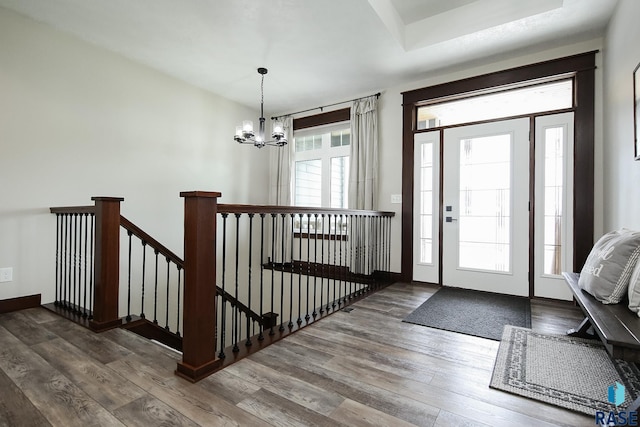 foyer with a notable chandelier and wood finished floors