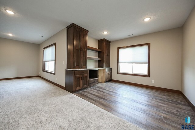 unfurnished living room with baseboards, recessed lighting, dark wood-style floors, and visible vents