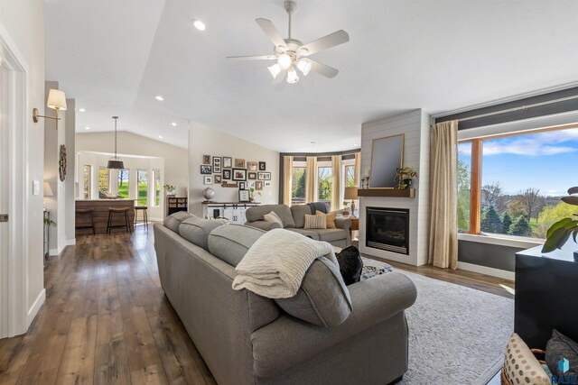 living room with ceiling fan, dark wood finished floors, baseboards, lofted ceiling, and a glass covered fireplace