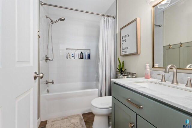bathroom featuring vanity, shower / bath combo with shower curtain, toilet, and wood finished floors