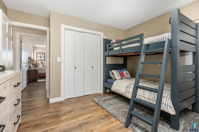 bedroom with light wood finished floors and a closet