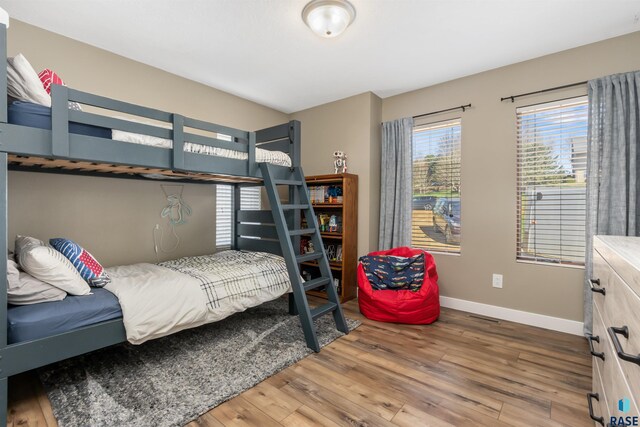 bedroom featuring baseboards and wood finished floors