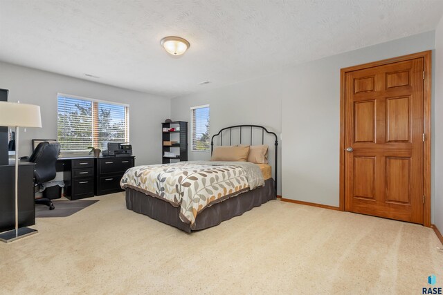 bedroom with light colored carpet and baseboards