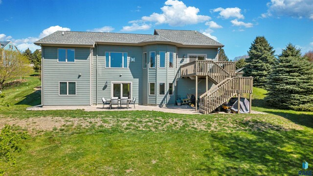 rear view of house featuring stairs, a lawn, a deck, and a patio