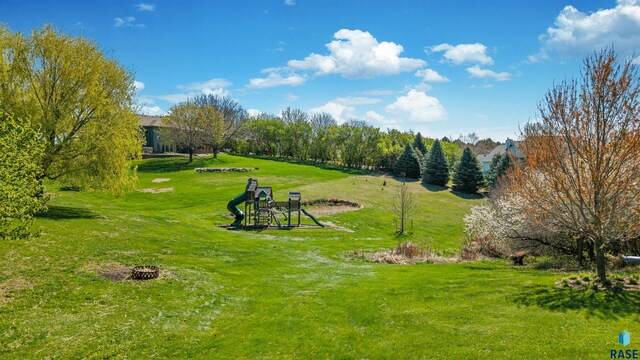 view of community featuring a lawn and a fire pit