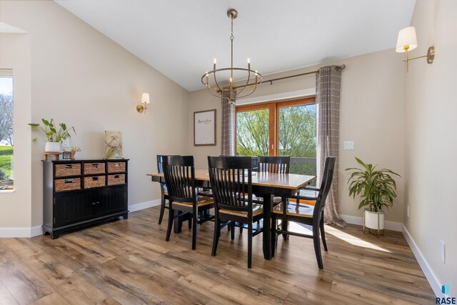 dining area featuring an inviting chandelier, baseboards, and wood finished floors