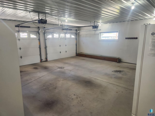 garage featuring freestanding refrigerator and a garage door opener