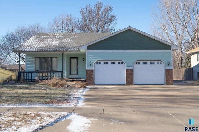 view of front of home featuring covered porch, brick siding, concrete driveway, and a garage