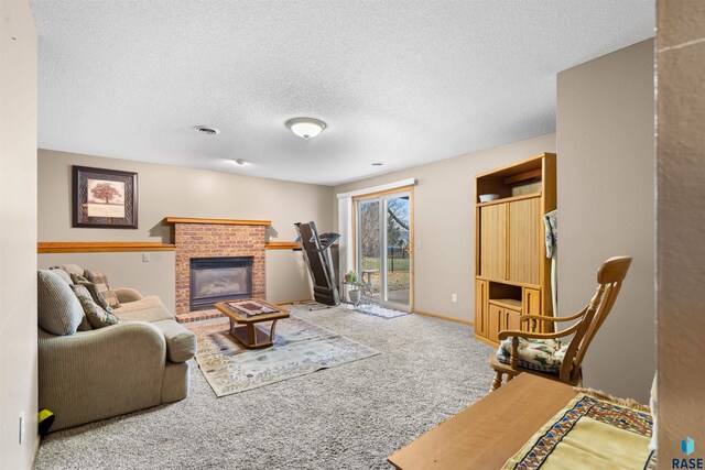 living room featuring a textured ceiling, visible vents, a brick fireplace, baseboards, and carpet