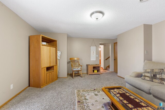 living room with light colored carpet, a textured ceiling, stairs, and baseboards