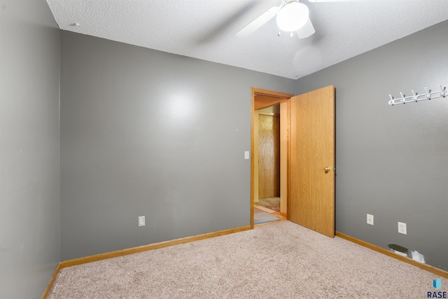 unfurnished bedroom featuring carpet floors, baseboards, and a ceiling fan