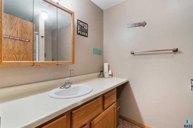 bathroom with vanity, baseboards, and visible vents