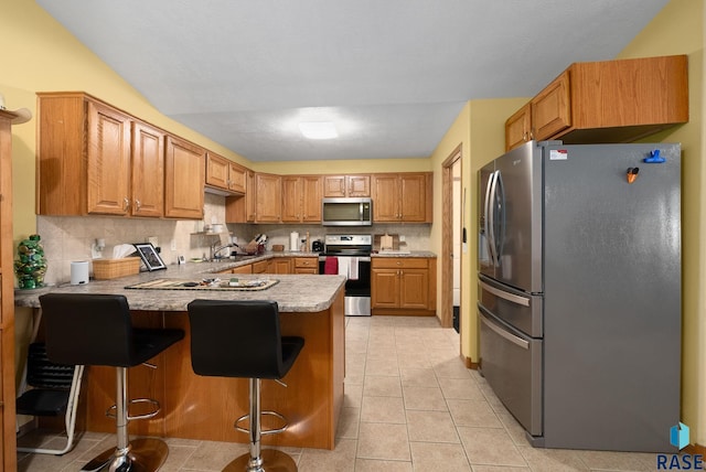 1012 E Magnolia Dr, Brandon, SD 57005 - kitchen featuring appliances with stainless steel finishes, a sink, light countertops, a peninsula, and backsplash
