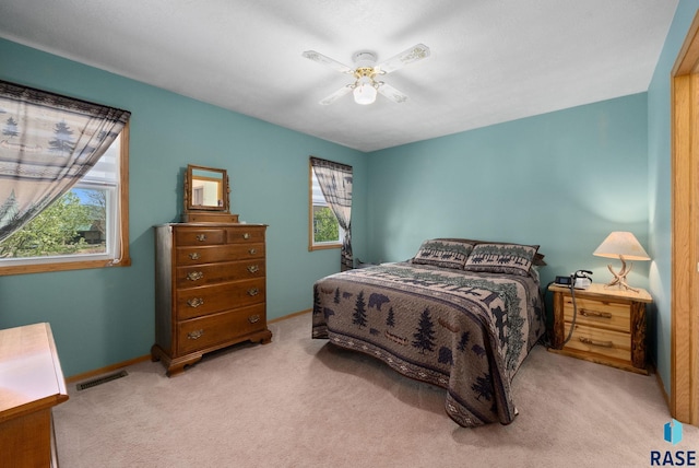 carpeted bedroom with baseboards, a ceiling fan, and visible vents