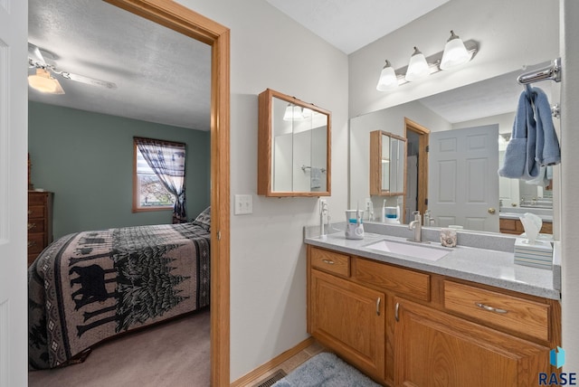 bathroom with visible vents, vanity, ensuite bathroom, baseboards, and ceiling fan