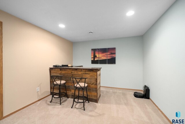 bar with baseboards, carpet, recessed lighting, and a bar