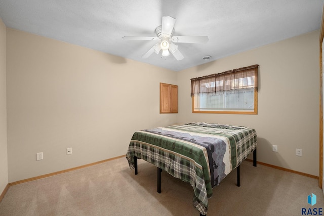 bedroom with baseboards, ceiling fan, and light carpet