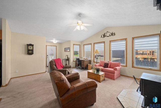 living room featuring baseboards, ceiling fan, lofted ceiling, and light carpet