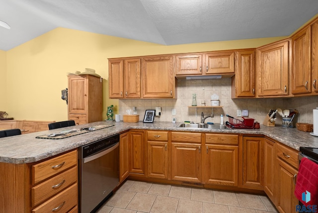 kitchen featuring appliances with stainless steel finishes, vaulted ceiling, brown cabinets, a sink, and a peninsula