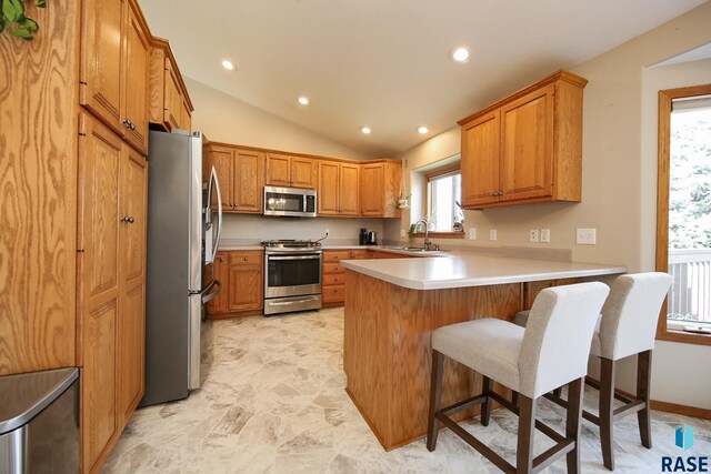3219 S Grace Ave, Sioux Falls, SD 57103 - kitchen with a peninsula, lofted ceiling, light countertops, a sink, and stainless steel appliances