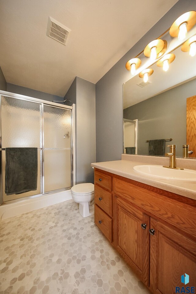 3219 S Grace Ave, Sioux Falls, SD 57103 - bathroom with vanity, a shower stall, toilet, and visible vents