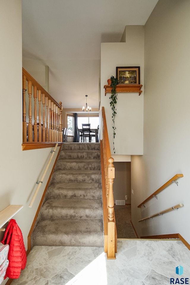 3219 S Grace Ave, Sioux Falls, SD 57103 - stairway featuring baseboards, a notable chandelier, and visible vents