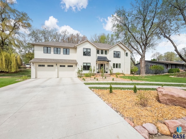 view of front of home with a garage, a front lawn, and driveway