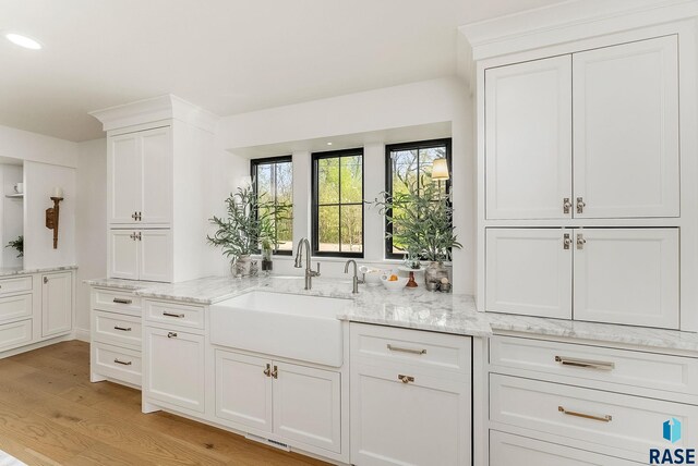interior space featuring recessed lighting, a sink, and light wood-style floors
