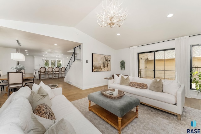 living room with recessed lighting, a notable chandelier, light wood finished floors, and vaulted ceiling