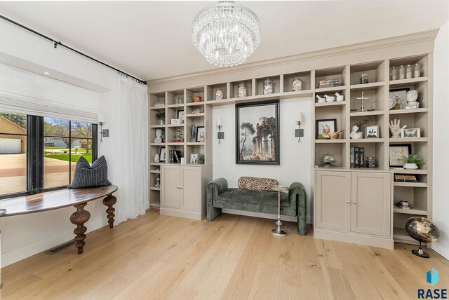 interior space with baseboards, a chandelier, light wood-style flooring, and visible vents