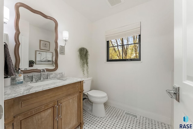 bathroom featuring toilet, baseboards, visible vents, and vanity