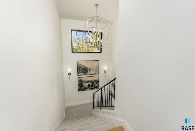 stairs featuring baseboards, carpet, and a chandelier
