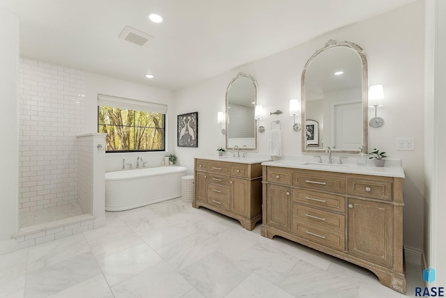 full bath featuring visible vents, two vanities, a sink, and a freestanding bath