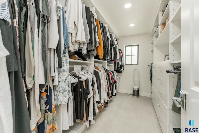 walk in closet with light carpet