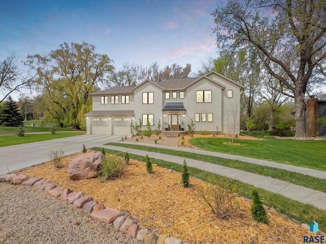 view of front of property with an attached garage, concrete driveway, and a front yard