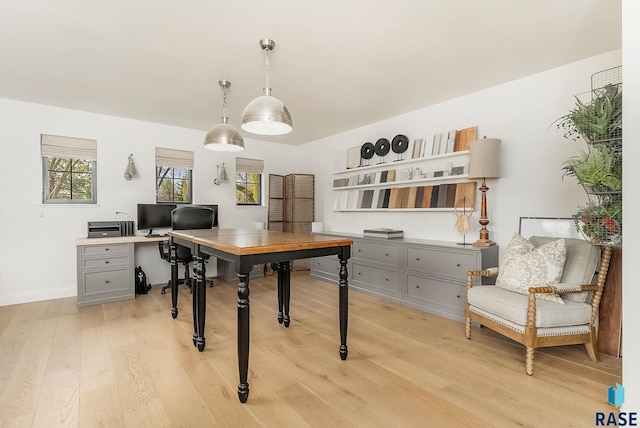 office space featuring baseboards and light wood finished floors