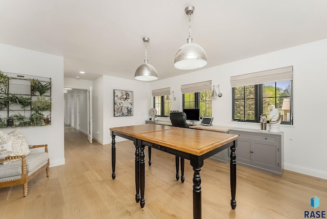 dining area featuring baseboards and light wood-type flooring