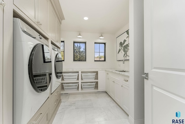 clothes washing area with washing machine and clothes dryer, cabinet space, a sink, marble finish floor, and recessed lighting